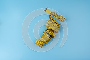Measuring tape of tailor with indicators in form of centimeters. Yellow rolled measuring tape