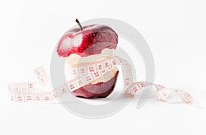 Measuring tape wrapped around apple as a symbol of diet.