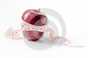 Measuring tape wrapped around apple in fat boy hand,as a symbol