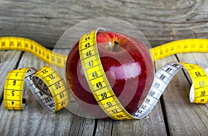 Measuring tape wrapped around a apple weight loss