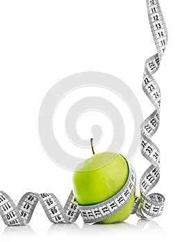 Measuring tape wrapped around a green apple