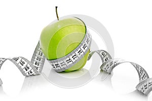 Measuring tape wrapped around a green apple