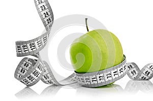 Measuring tape wrapped around a green apple