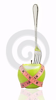 Measuring tape wrapped around a green apple