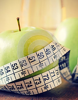 Measuring tape wrapped around a green apple