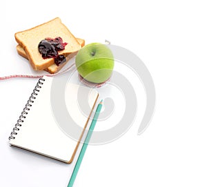 Measuring tape wrapped around a green apple with Slice of white