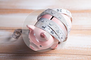 Measuring tape wrapped around the piggy bank