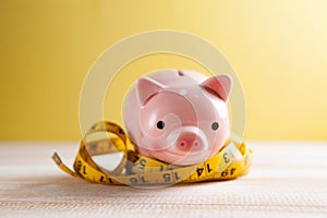 Measuring tape wrapped around the piggy bank