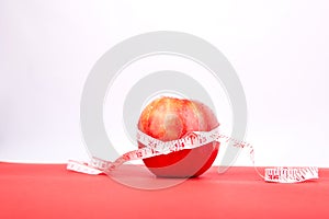 Measuring tape wrapped around a red apple