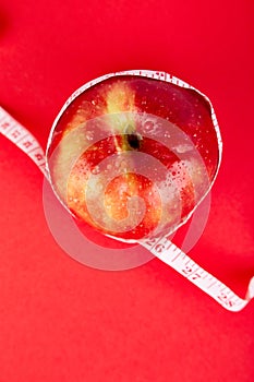 Measuring tape wrapped around a red apple