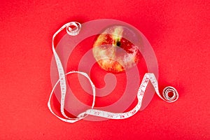 Measuring tape wrapped around a red apple