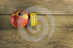 Measuring tape wrapped around a red apple