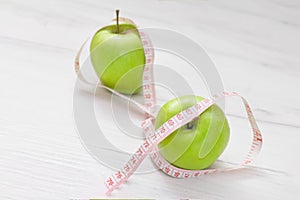 Measuring tape wrapped around two green apple isolated on white background, Concept of the goal to lose weight,the goal