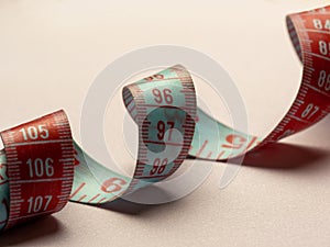 measuring tape writhing lies on a pink background