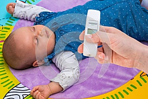 Measuring temperature to a baby with thermometer
