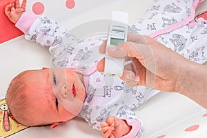 Measuring temperature to a baby with thermometer