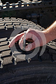 Measuring tread depth tractor-trailer truck tire photo