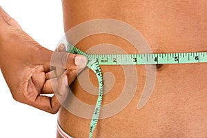 Measuring waist, close up of ethnic woman abdomen