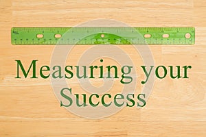 Measuring your Success message with a plastic ruler on a desk