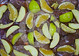 Meat with apples and oranges in spices, top view