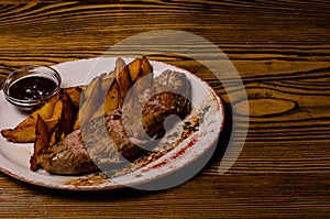 Meat balls with potatoes in a baking dish and sour cream close-up on a table. horizontal view from above