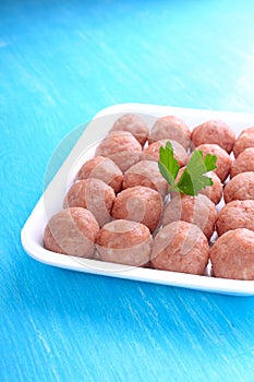 Meat balls from raw minced meat in a white tray