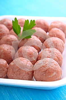 Meat balls from raw minced meat in a white tray