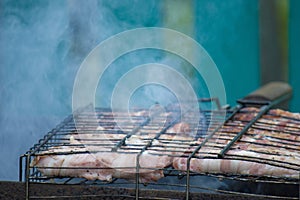 Meat barbecue. Sausages with cheese spun in bacon on a metal grill close-up