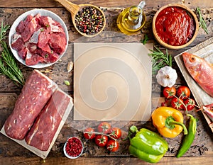 Meat based food ingredients arranged around blank paper