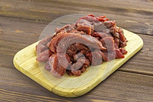 Meat beef cut into pieces lies on a wooden Board