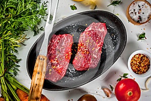 Raw beef steaks with vegetables