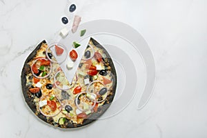meat black dough Pizza with vegetables on white marble background with ingredients. Flying food concept.