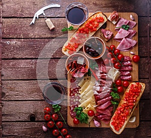 Meat and cheese appetizer set for red wine on rustic background, flatlay, copy space.