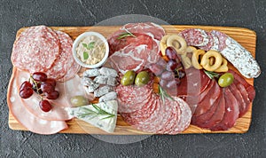 Meat and cheese board with products from Italy - prosciutto, mortadella, felino, bresaola, gorgonzola, parmesan, pate, green photo