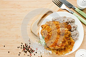 Meat chop in bread crumbs garnished with green buckwheat, hearty