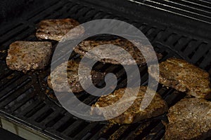 The meat is cooked on a gas grill. Barbecue, delicious juicy grilled