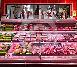 Meat counter refrigerator with packaged and prepackaged meat in a butcher shop