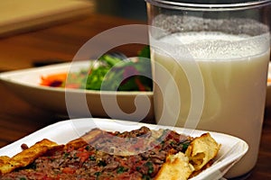 Meat cubed pitta bread drinkable yoghurt and salad on wooden background close up view