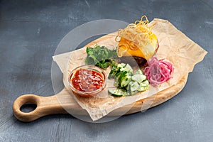 Meat cutlet with cheese with fresh vegetables on the wood