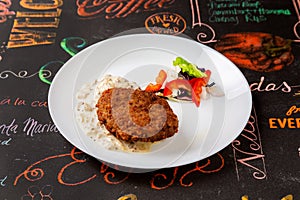 Meat cutlet in a plate on a table