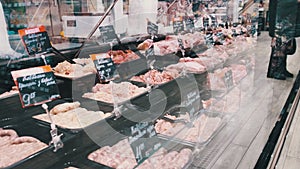 Meat Department in Supermarket. Glass Showcase with Fresh Raw Meat, Price Tags