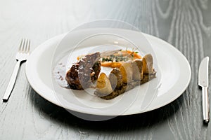 Meat dish with boiled potatoes on the white table