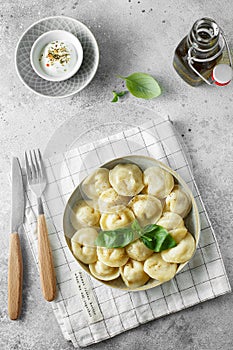 Meat dumplings - russian pelmeni, ravioli with meat on a white plate. Flat lay composition