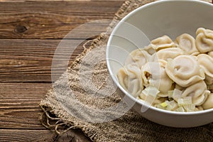 Meat dumplings - russian pelmeni, ravioli with meat on a white plate