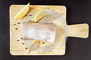 Meat fish, pepper peas, bay leaf and lemon closeup. Ingredients for dish from seafood. Top view