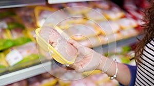 Meat in food store . Woman choosing packed fresh chicken meat in supermarket