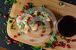 Meat with greens and berries. Wild meat on a wooden board