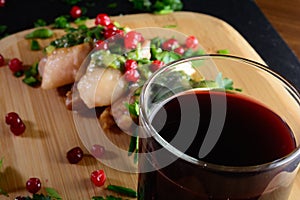 Meat with greens and berries and wine. Meat on a wooden board