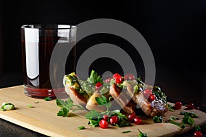 Meat with greens and berries and wine. Meat on a wooden board