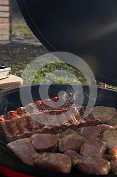 The meat is grilled on a portable charcoal grill